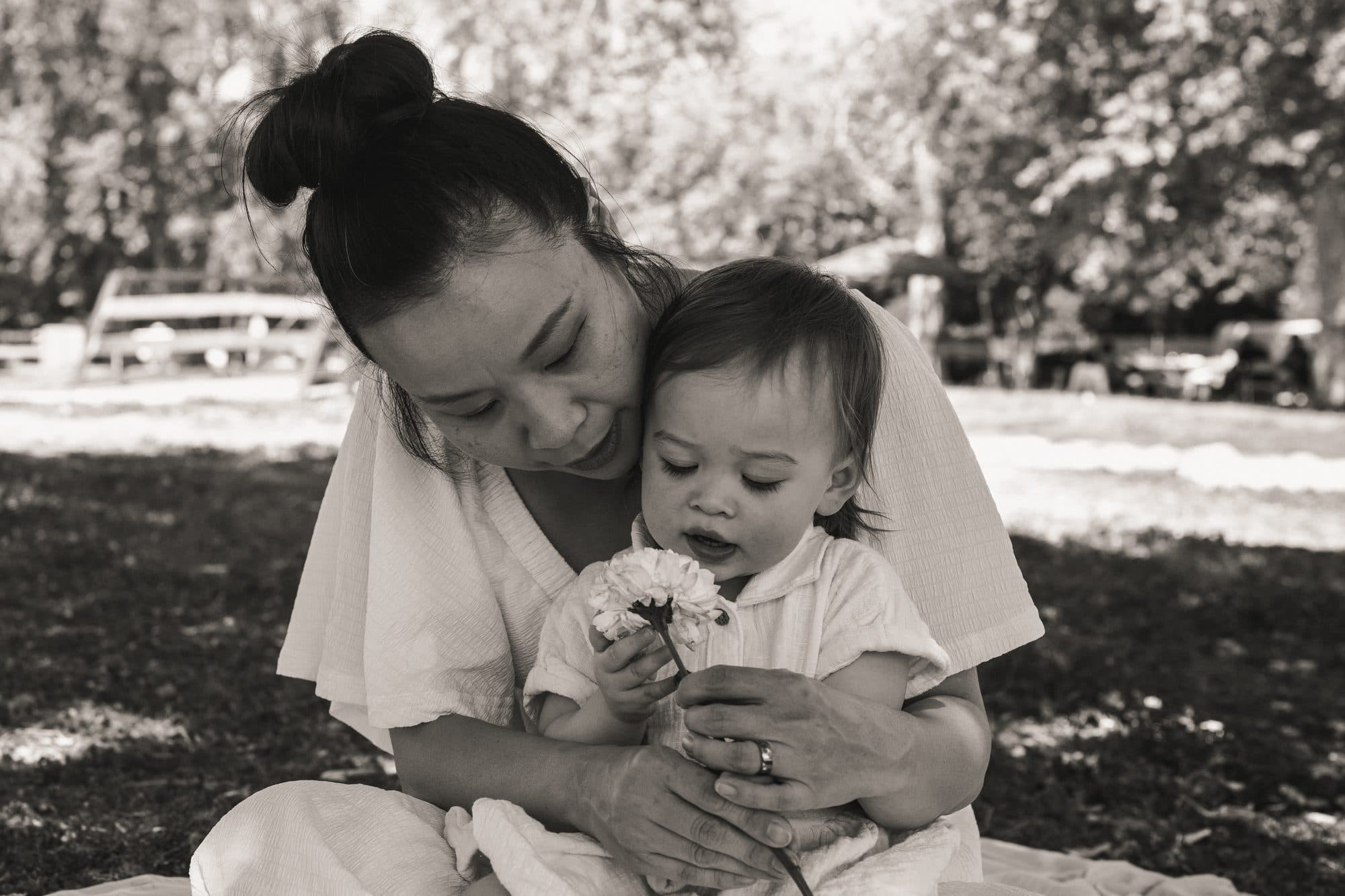 Mother and toddler with wildflowers in a Los Angeles park, black and white