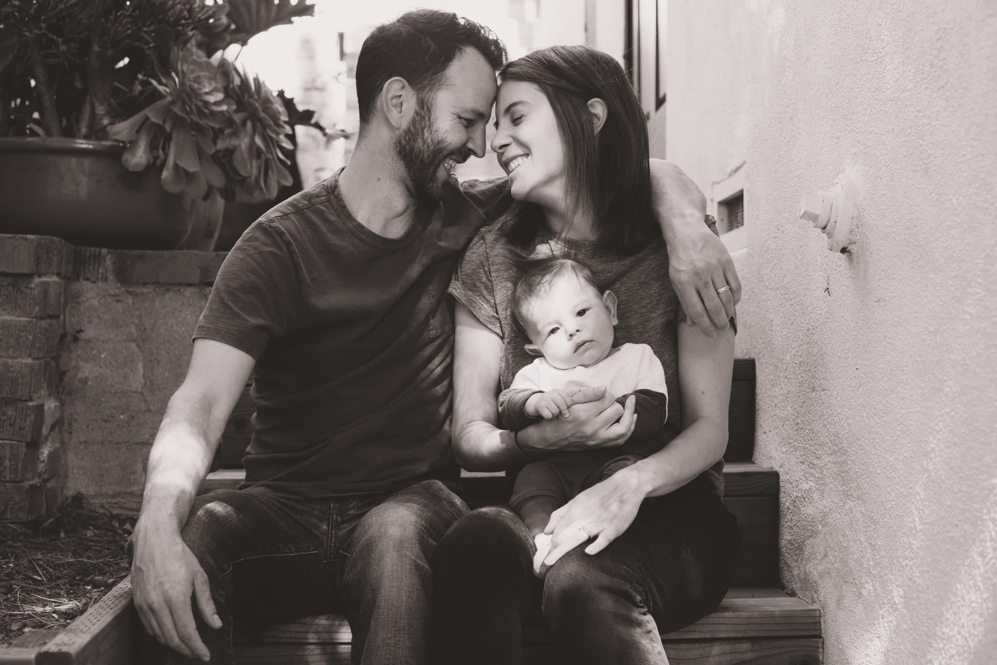 Parents with their newborn on the front steps, black and white