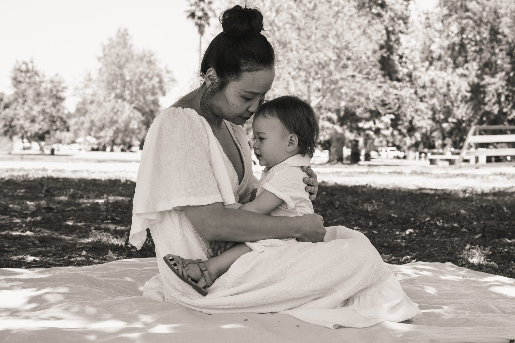 Mother embracing her child on the grass, black and white