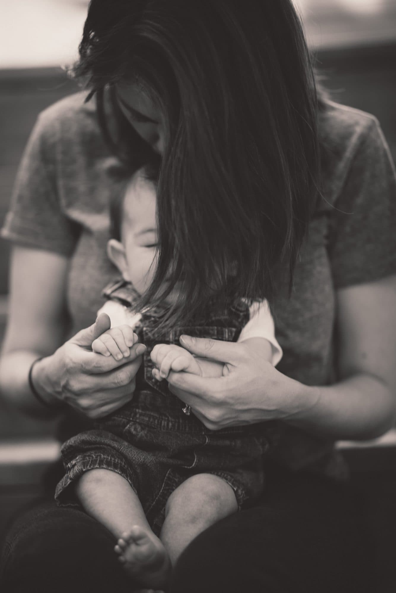 Mother holding her newborn close, black and white