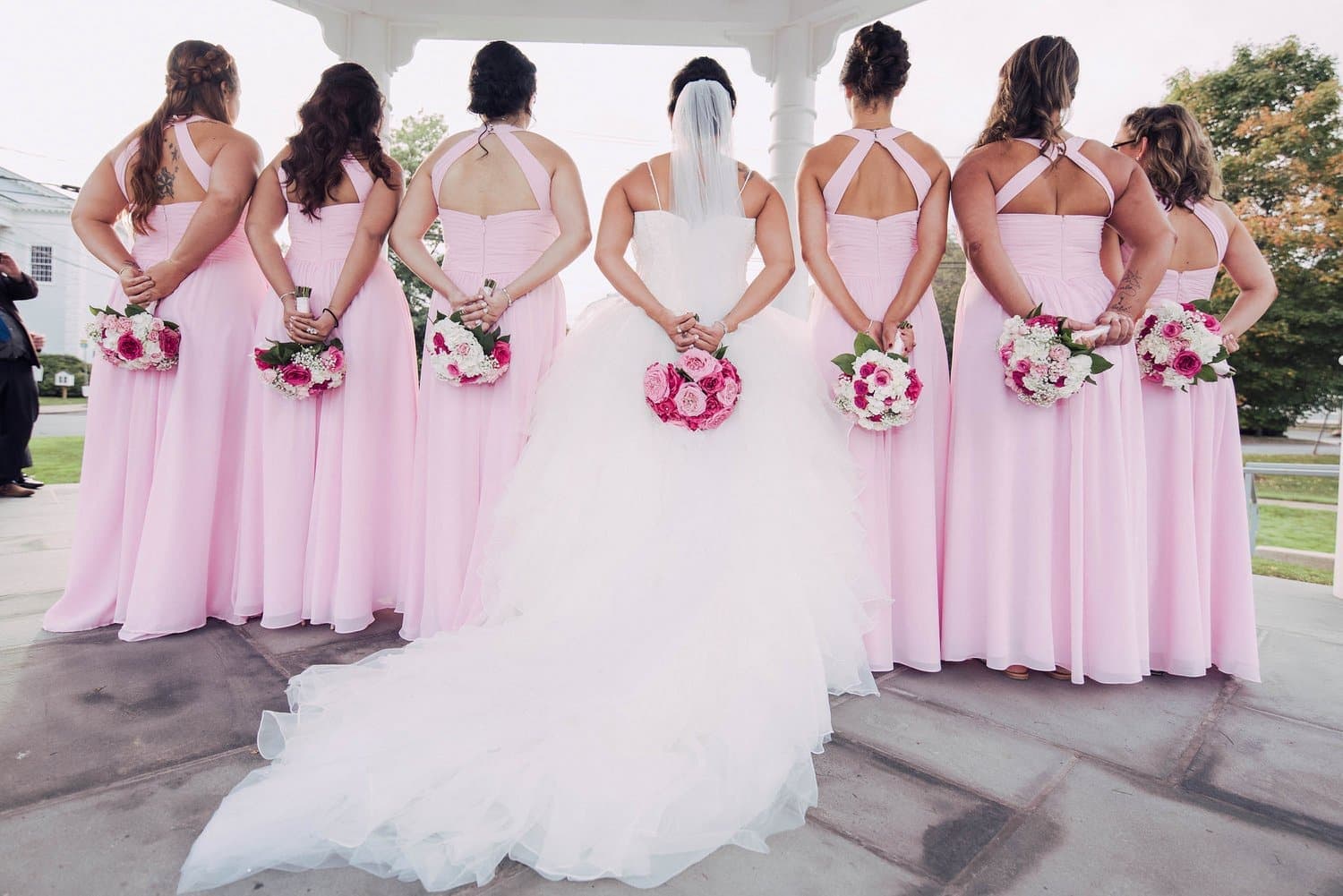 Bride and bridesmaids from behind with bouquets